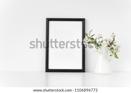 Black A4 passepartout frame mock up with spring cherry bouquet. Mock up for your photo, design or text.