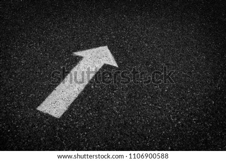 Arrow painted on street with white paint asphalt for directions and safety driving on road