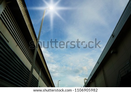Lighting poles and buildings with blue sky                               