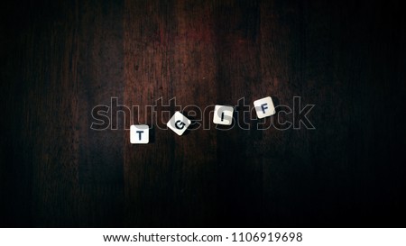 Wording block “TGIF” with wood background. Royalty-Free Stock Photo #1106919698