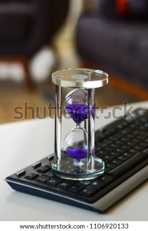 Time is money, make money and time management business and technology concept, hourglass on laptop keyboard macro view. deadline idea, symbol, concept