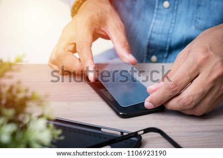 The man replacing the broken tempered glass screen protector for smartphone. Royalty-Free Stock Photo #1106923190