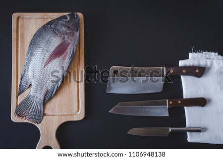 Raw fresh fish on choping board  prepared for cooking with knife