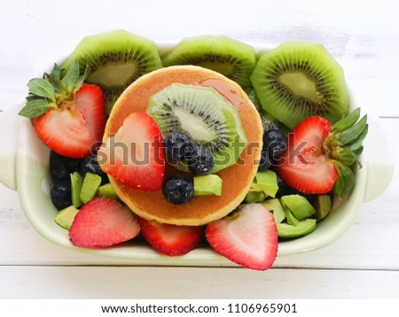 A pancake with mixed fruits and honey