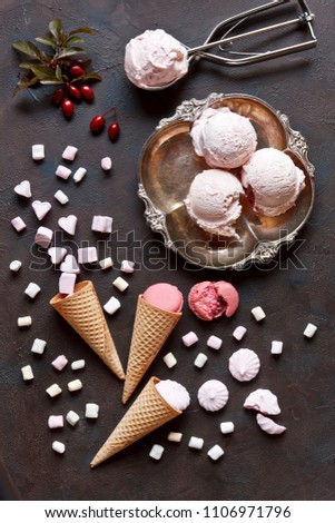 Fresh homemade ice cream with waffle cones, marshmallow, macaroons and meringues. Close-up view, close-up on vintage dark background