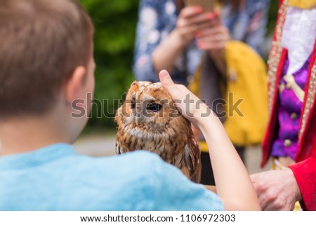 man holding an owl outdoors at the festival