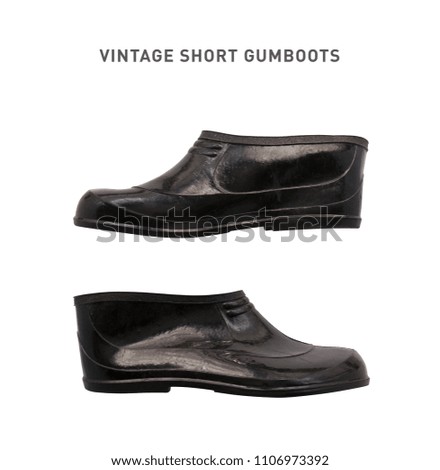 A pair of black short vintage gumboots, rubber boots for rainy weather. Isolated, side view.
