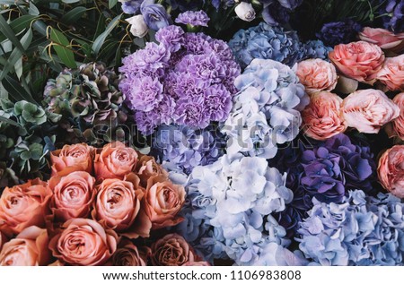 Beautiful blossoming flowers (roses, hydrangeas, carnations, eustoma) in blu, antique blue and peach colours at the florist shop Royalty-Free Stock Photo #1106983808