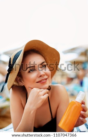 Young Woman in Bikini  Holding  Bottles of Sun Cream in Her Hands. Skincare. A Female  Applying  Sunscreen.