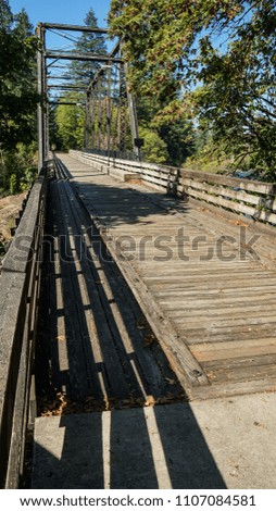 A footbridge for pedestrians and bicycles, converted from an old train trestle, with interesting shadows cast by the railings.                        