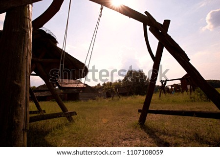Abandoned swing in warm sunny light, in the spring season