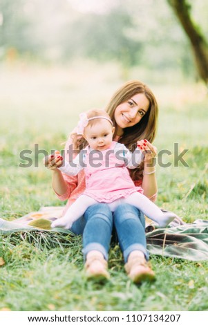 Happy cheerful family. Mother and baby kissing, laughing and hugging in nature outdoors