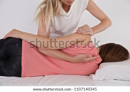 Woman having chiropractic back adjustment. Osteopathy, Physiotherapy, sport injury rehabilitation concept, holistic care Royalty-Free Stock Photo #1107140345