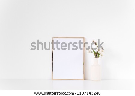 Gold frame mock up with spring feminine flowers. Mockup for your photo, design or text.