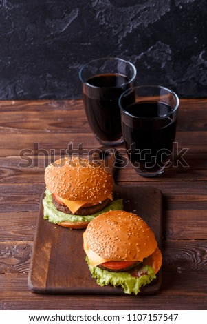 Photo of two fresh hamburgers and two glasses of juice