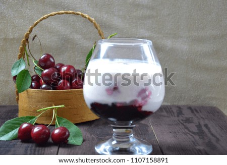 Cherry yogurt dessert and ripe cherry on a wooden table. Summer dessert.