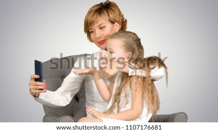 Happy woman and child taking a selfie on white background