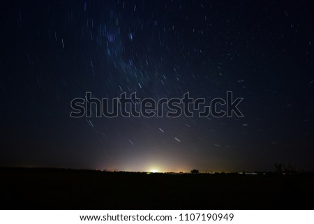  circumpolar on a summer night, with a starry night, and at the edge of the horizon the light pollution of the nearest city