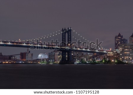 Light trails along the Manhattan Bridge at night on a cloud day. View from Manhattan. 20 second exposure.