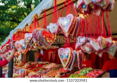 Festival traditional sweet candy hearts hanging on stand outdoor.Holiday edible decoration in Europe