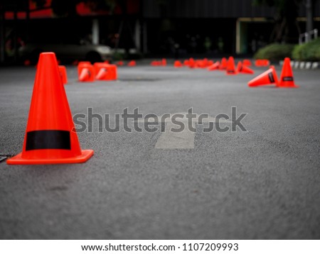 Close up shot of orange traffic cones that set up to be mini track for Gymkhana race or practice. Insert your logo on the cone and text space on asphalt