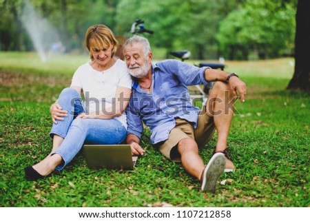 Portrait caucasian senior woman and old man, couple elder in love happy in park playing social network or social media on notebook or laptop, shopping online