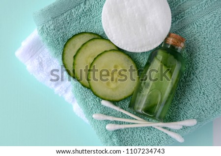 Fresh cucumber slices and natural beauty face toner in a glass bottle with copy space. SPA and beauty concept.