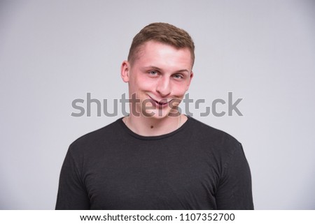 portrait of a cute young guy on a white background in different poses with different emotions. He stands directly in front of the camera and smiles