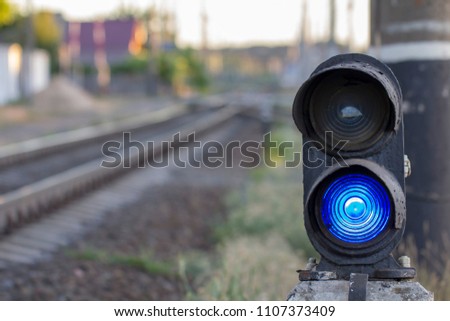 Traffic light on railway tracks. Blue light is on.
