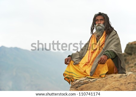 Indian old monk sadhu in saffron color clothing Royalty-Free Stock Photo #110741174