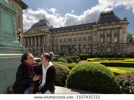 Mother and daughter next to the royal palace with its gardens in Brussels capital of Belgium. Horizontal take of day.