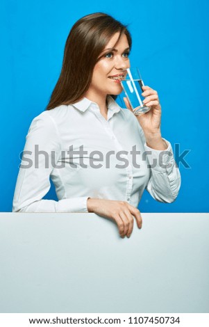 Woman in white shirt drinking water with glass. Clear copy space below portrait.