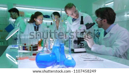 Focus on Science Lab Glassware with Forensics Team Researchers Work for a Medical Scientific Project in Chemistry Laboratory Room