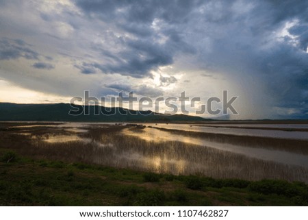  lake view at sunset with rain and storm background in countryside.