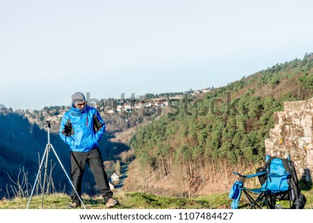 tourist photographer by nature making a break from a mountain peak with edgy sports equipment