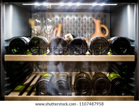 Wine bottles cooling in refrigerator Royalty-Free Stock Photo #1107487958