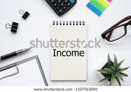 Top view white background desktop with Notebook write text Income for business and finance concept.