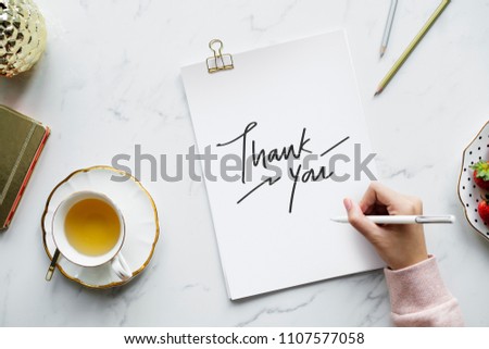 Woman writing a thank you note Royalty-Free Stock Photo #1107577058