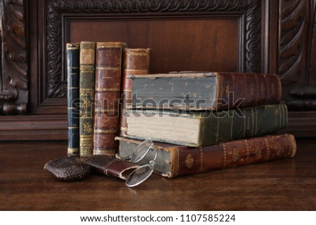 old books piled on an antique wooden furniture