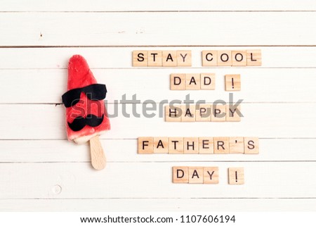 Father's Day greeting card with funny ice cream and wooden tiles comic text on white wooden background. Stay cool, dad.