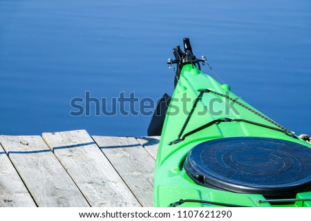 A green kayak on a wooden jetty / bridge deck. Copy space for text. Royalty-Free Stock Photo #1107621290