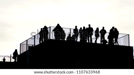 Silhouettes of people. A group of people made up of men and women on a terrace, a very contrasted light image.