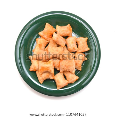 A serving of bite size pizza rolls isolated in green plate on a white background. Royalty-Free Stock Photo #1107641027