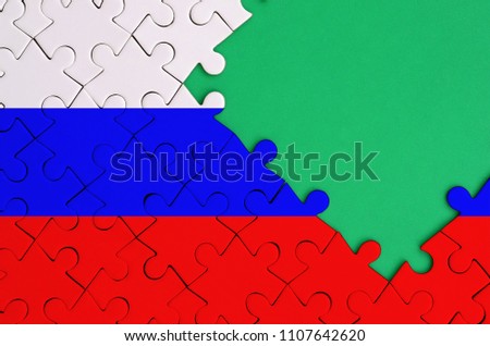 Russia flag  is depicted on a completed jigsaw puzzle with free green copy space on the right side