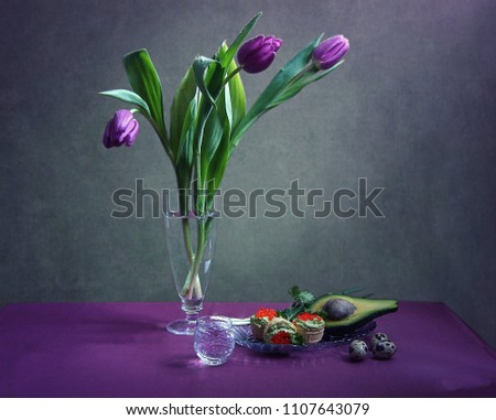Still life with a bouquet of purple tulips and delicious snacks