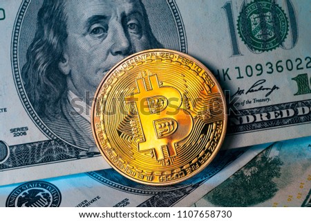 Golden Bitcoin coin on us dollar bills background