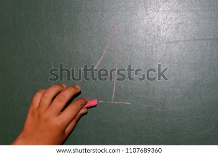 hand painting on blackboard with red chalk