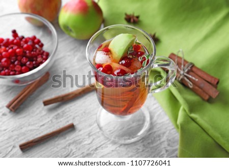 Beverage with apples and cranberry in glass cup on wooden table