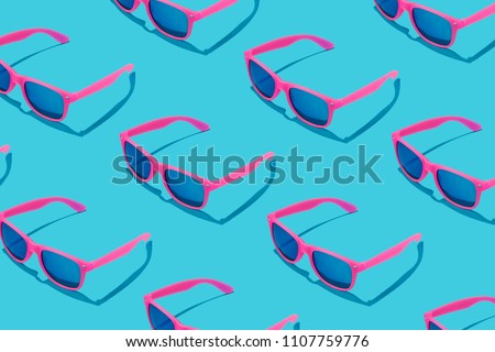 Pink sunglasses pattern on pastel blue background. Minimal summer concept. Royalty-Free Stock Photo #1107759776