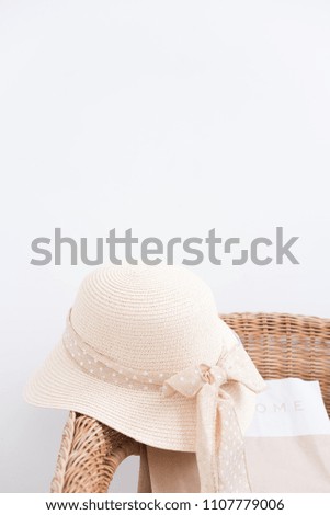 Straw hat on natural wooden chair on white wall background